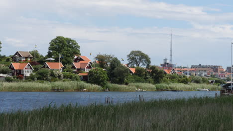 Red-Summer-Houses-Along-River,-Karlskrona,-Sweden