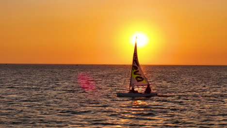 Sailing-Away-On-A-Colorful-Golden-Sunset-Sky-Above-The-Sea-Horizon