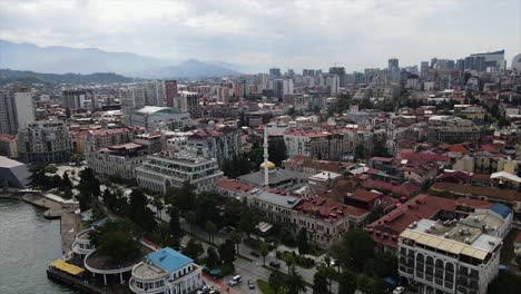 Aerial-view-of-Batumi-city-buildings-roads-cars-coast-black-sea-mountains-hotels-towers-bouts-ships