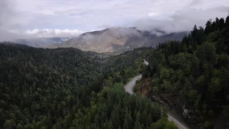 Vista-Superior-Con-Drones-Para-Montañas-Verdes-Con-Niebla-En-Un-Día-Nublado,-Por-La-Tarde,-Autos-De-Carretera