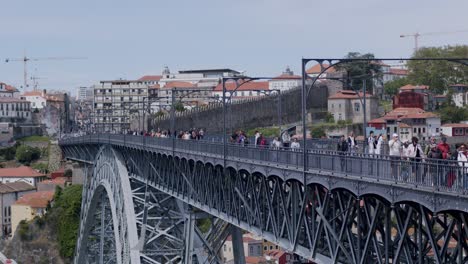 People-crossing-the-Dom-Luís-I-Bridge-in-Porto-on-a-sunny-day---tele,-side-view