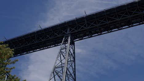 Pan-right-to-left-on-Dom-Luís-Bridge-in-Porto,-seen-from-a-below-angle