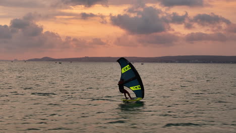 Wing-Foil-Ausrüstung,-Marke-Und-Produktleistung:-Junger-Profisportler-Gleitet-Mit-Herausragender-Effizienz-Und-Kontrolle-über-Das-Wasser