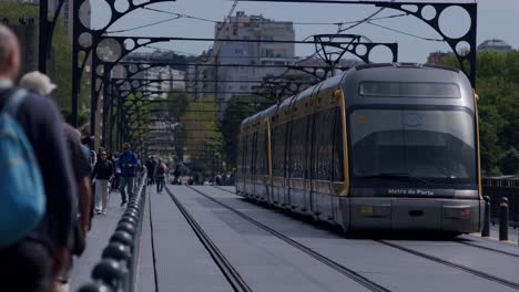 Tram-subway-of-Porto-crossing-Dom-Luís-I-Bridge-with-people-walking,-slow-motion