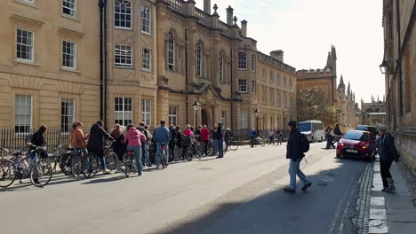 Groups-of-people-on-a-bike-tour-of-historical-places-and-buildings-in-Oxford-City,-England-UK