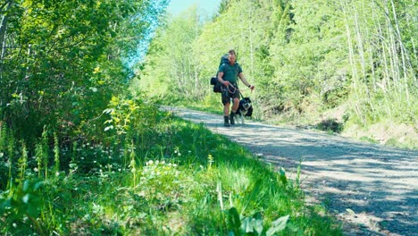 Norwegischer-Rucksacktourist-Mit-Alaskan-Malamute-Hund-Durch-Waldwege