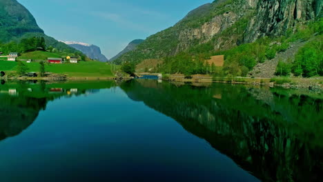 Idyllic-Norwegian-fjord-landscape-with-calm-waters,-green-hills,-and-mountain-reflections