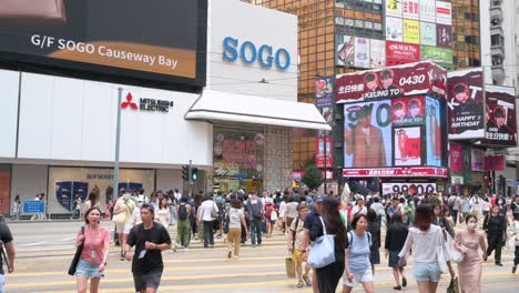 An-Der-Belebten-Kreuzung-In-Wan-Chai,-Hongkong,-überqueren-Fußgänger-Und-Käufer-Die-Straße-Vor-Dem-Japanischen-Kaufhaus-Sogo