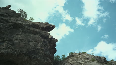 Mirando-Al-Cielo-Con-Nubes-En-Movimiento-Sobre-Las-Montañas,-Altos-Acantilados-Y-Nubes