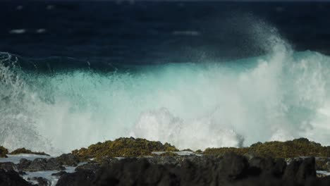 Slow-Motion-shot-of-strong-ocean-waves-flooding-lava-rocks-on-coast-of-Hawaii