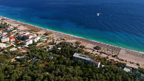 Aeria-view-tilting-toward-a-beach-on-the-Albanska-riviera,-sunny-day-in-Albania