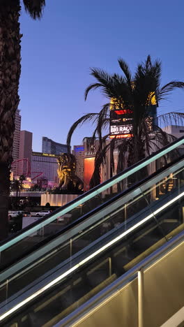 Vertical-4k,-MGM-Grand-and-New-York-New-York-Casino-Hotels-in-Lights-at-Twilight,-Escalator-POV,-Las-Vegas-USA