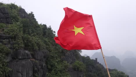 red-Vietnamese-flag-flapping-in-the-wind-in-the-mountainous-region-of-Ninh-Ninh-in-Northern-Vietnam