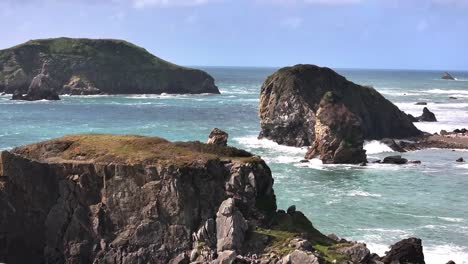 Experience-the-stunning-rocky-coast-of-California-with-this-aerial-pull-back-shot,-revealing-dramatic-cliffs,-crashing-waves,-and-the-rugged,-untamed-beauty-of-the-Pacific-shoreline