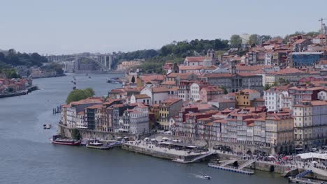 Panorama-and-skyline-view-of-the-riverside,-houses-and-Arrábida-Bridge-on-the-background-on-a-sunny-day