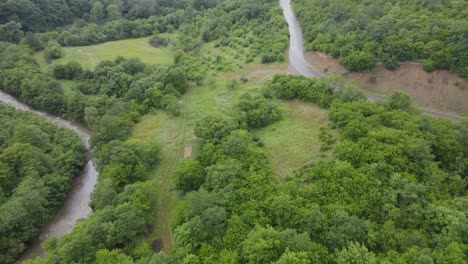 Aerial-view-of-mountains-village-country-road-in-beautiful-green-meadows-mountains