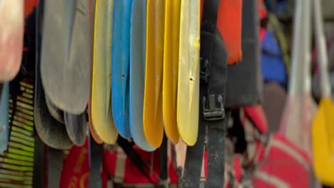 Plastic-boat-paddles-hanging-in-storage-room,-close-up-view