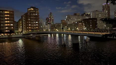 Eine-Friedliche-Abendliche-Stadtlandschaft-Mit-Einer-Brücke-über-Ruhiges-Wasser