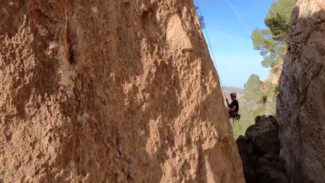 Hombre-Escalada-En-Roca-Vista-Aérea-Del-Deportista-Rappel-Montaña-En-La-Panocha,-El-Valle-Murcia,-España-Mujer-Rapel-Bajando-Una-Montaña-Escalando-Una-Gran-Roca