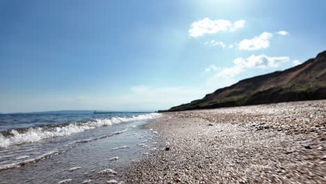 Eine-Wunderschöne-Strandszene-Mit-Klarem-Blauen-Wasser,-Weißen-Wolken-Und-Einem-Sandigen-Ufer