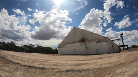 TIMELAPSE-of-White-grain-shed-in-storage-site-at-sunset-with-clouds-in-Western-Australia