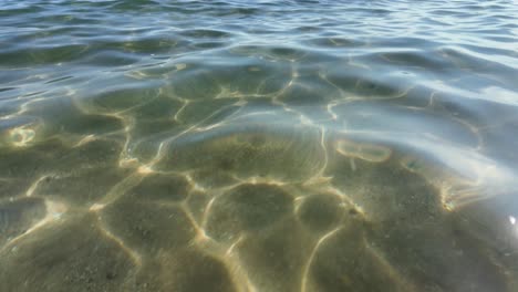 Crystal-clear-water-with-sun-glints-and-ripple-patterns-on-a-sunny-summer-day