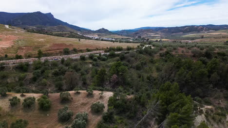 Landscape-of-Estepona-in-Spain-with-power-lines-bellow,-aerial-ascend-view