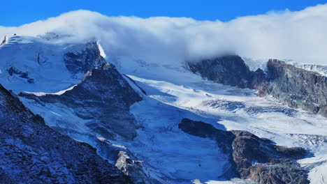 Morning-blue-bird-clear-sky-sunny-cloud-fog-layer-glacier-glacial-crevasse-Saas-Fee-Saastal-Zermatt-Switzerland-aerial-drone-gondola-Metro-Alpin-tram-Swiss-Alpine-Alps-chalet-valley-mountains-circle