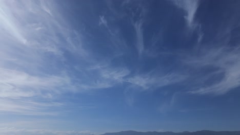 Vuelo-Con-Dron-Filmando-El-Cielo-Azul-Con-Un-Tipo-De-Nubes-Llamadas-Cirros,-Las-Observamos-Con-Un-Giro-De-Izquierda-A-Derecha-En-Un-Día-Soleado