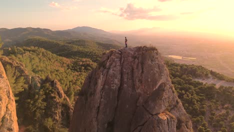 Man-rock-climbing-aerial-view-of-sportsman-rapelling-mountain-in-La-Panocha,-el-Valle-Murcia,-Spain-woman-rapel-down-a-mountain-climbing-a-big-rock