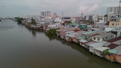 Kanal-Mit-Rustikalen-Barackenhäusern-Und-Neuer-Bebauung-In-Ho-Chi-Minh-Stadt,-Vietnam,-Abend-Drohnenvideo