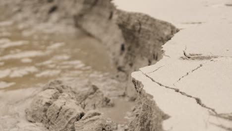 Process-of-beach-erosion,-cracking-sand,-sea-coastline