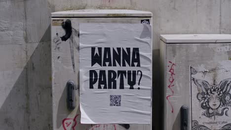 Party-poster-glued-to-an-electricity-box,-announcing-an-event-with-qr-code