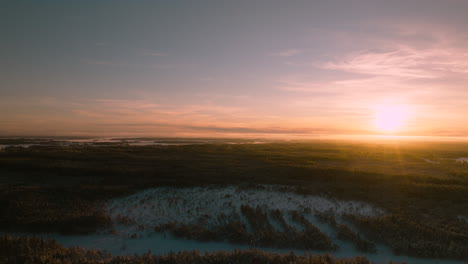 Colorful-sunset-in-winter-landscape,-drone-panning-from-left-to-right