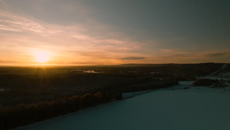 Drone-Ascendiendo-Sobre-La-Puesta-De-Sol-De-Invierno,-Paisaje-De-Bosque-De-árboles,-Suecia