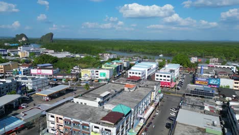 Stunning-aerial-view-flight-of-krabi-town-in-southern-thailand,-showing-a-mix-of-buildings,-a-river,-the-sea,-and-forested-hills-in-the-background