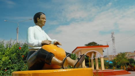 Escultura-De-Un-Percusionista-Afroperuano-Vistiendo-Trajes-Tradicionales-Tocando-Un-Instrumento-Musical-Llamado-&#39;checo&#39;-En-La-Plaza-Principal-De-Zaña,-Chiclayo,-Perú.