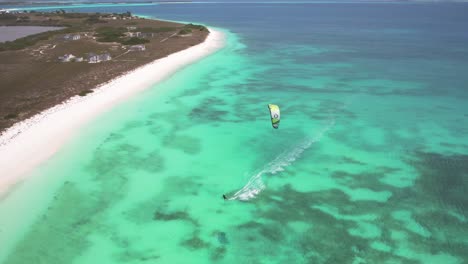 Kite-surfer-gliding-over-crystal-clear-turquoise-waters-near-a-tropical-beach