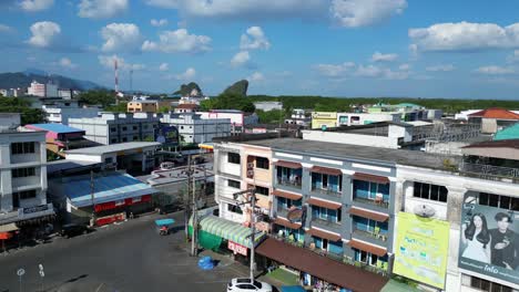 Gorgeous-aerial-view-flight-of-krabi-town-in-southern-thailand,-showing-a-mix-of-buildings,-a-river,-the-sea,-and-forested-hills-in-the-background