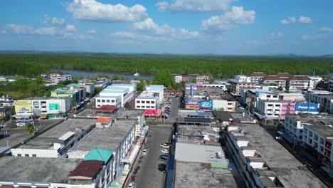 Amazing-aerial-view-flight-of-krabi-town-in-southern-thailand,-showing-a-mix-of-buildings,-a-river,-the-sea,-and-forested-hills-in-the-background