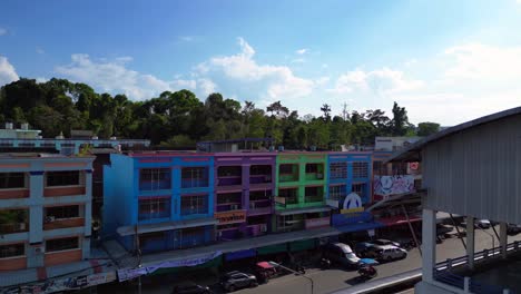 Fabulous-aerial-view-flight-of-colorful-houses-krabi-town-in-southern-thailand,-showing-a-mix-of-buildings,-a-river,-the-sea,-and-forested-hills-in-the-background