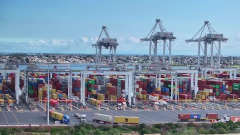 Aerial-reveal-of-trucks-and-cranes-handling-containers-at-Webb-Dock-in-Port-Melbourne