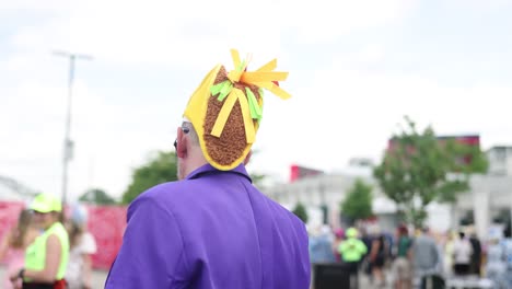 Footage-of-a-guy-wearing-a-taco-shaped-hat,-adding-to-the-festive-atmosphere-of-the-Kentucky-Derby-150-tailgate-outside-Churchill-Downs