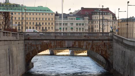 Rustikale-Steinbrücke-über-Das-Wasser-Im-Zentrum-Von-Stockholm-Mit-Historischen-Gebäuden-Im-Hintergrund