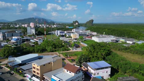 Majestic-aerial-view-flight-of-krabi-town-in-southern-thailand,-showing-a-mix-of-buildings,-a-river,-the-sea,-and-forested-hills-in-the-background