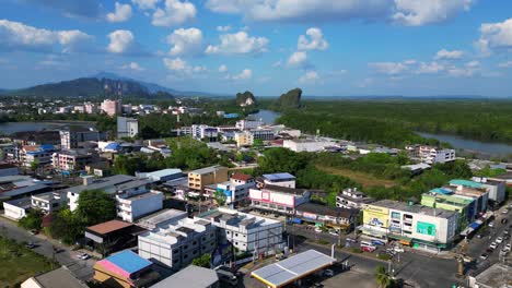 Wunderbarer-Luftbildflug-Der-Stadt-Krabi-Im-Süden-Thailands,-Der-Eine-Mischung-Aus-Gebäuden,-Einem-Fluss,-Dem-Meer-Und-Bewaldeten-Hügeln-Im-Hintergrund-Zeigt