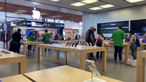 Movimiento-De-Personas-Jugando-Un-Nuevo-IPhone-Dentro-De-La-Tienda-Apple-Con-Resolución-4k