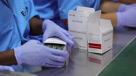 worker-packing-medicine-capsules-and-arranging-them-inside-the-box