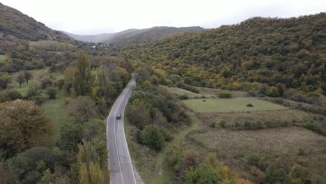 Aerial-view-of-mountains-village-country-road-in-beautiful-green-meadows-mountains-valley