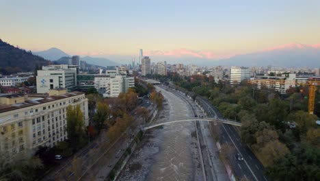 Aerial-tops-Mapocho-river-fly-above-Chilean-Capital-Santiago-green-park-traffic-in-Balmaceda-neighborhood